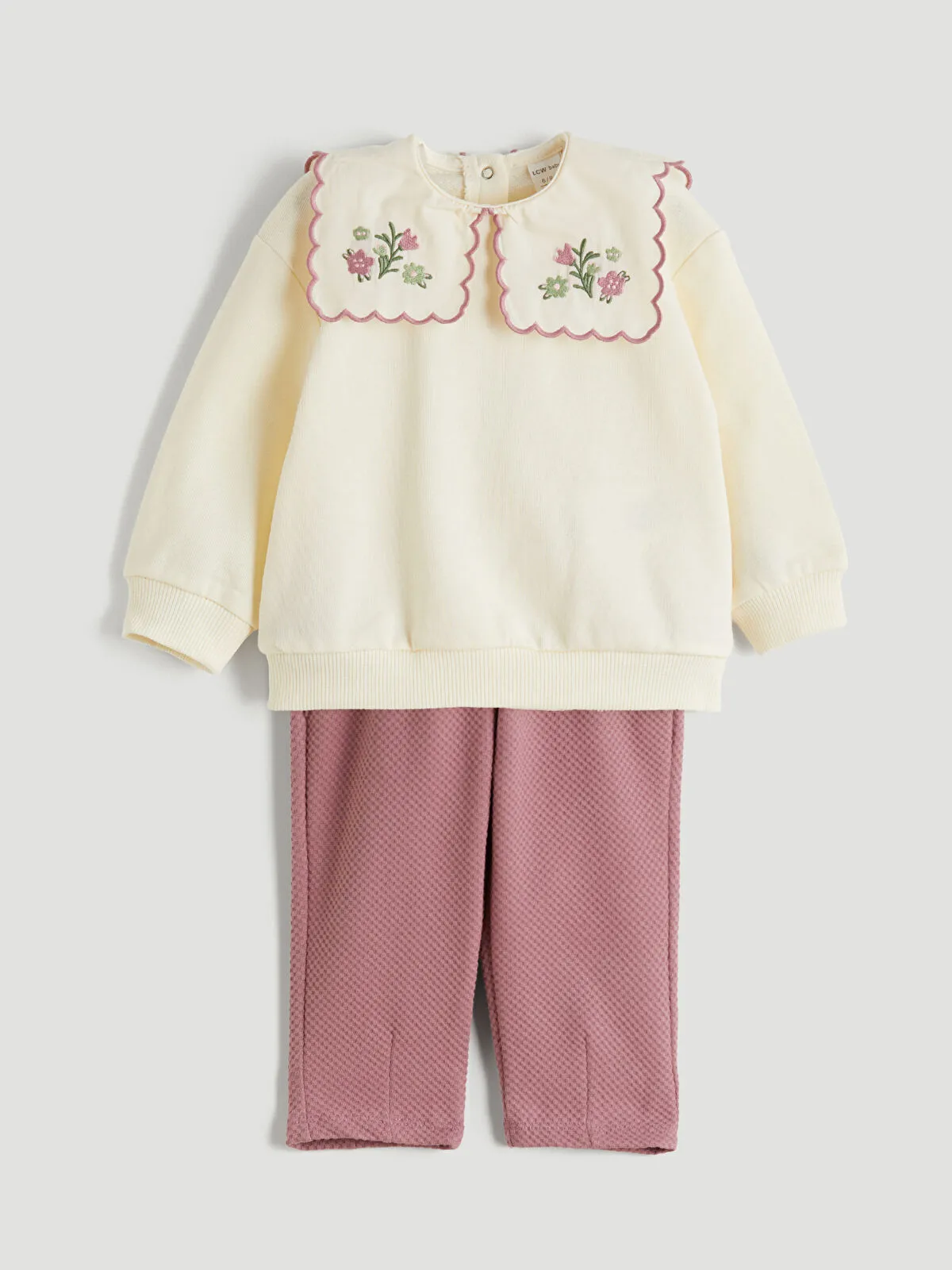 Off-white Peter Pan collar girl's blouse and trousers.