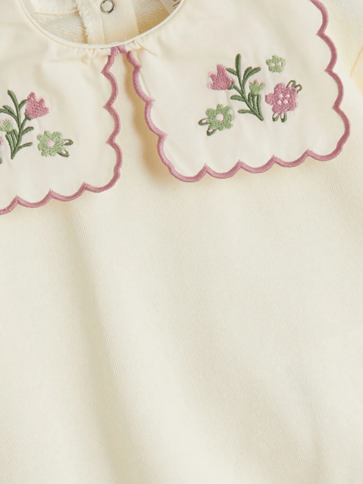 Off-white Peter Pan collar girl's blouse and trousers.