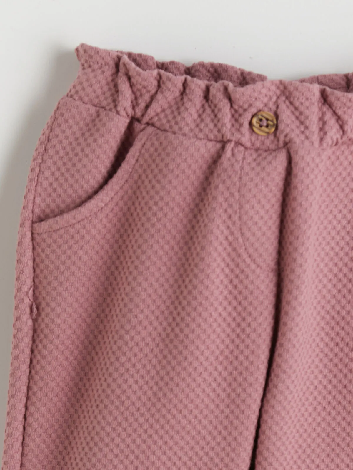 Off-white Peter Pan collar girl's blouse and trousers.