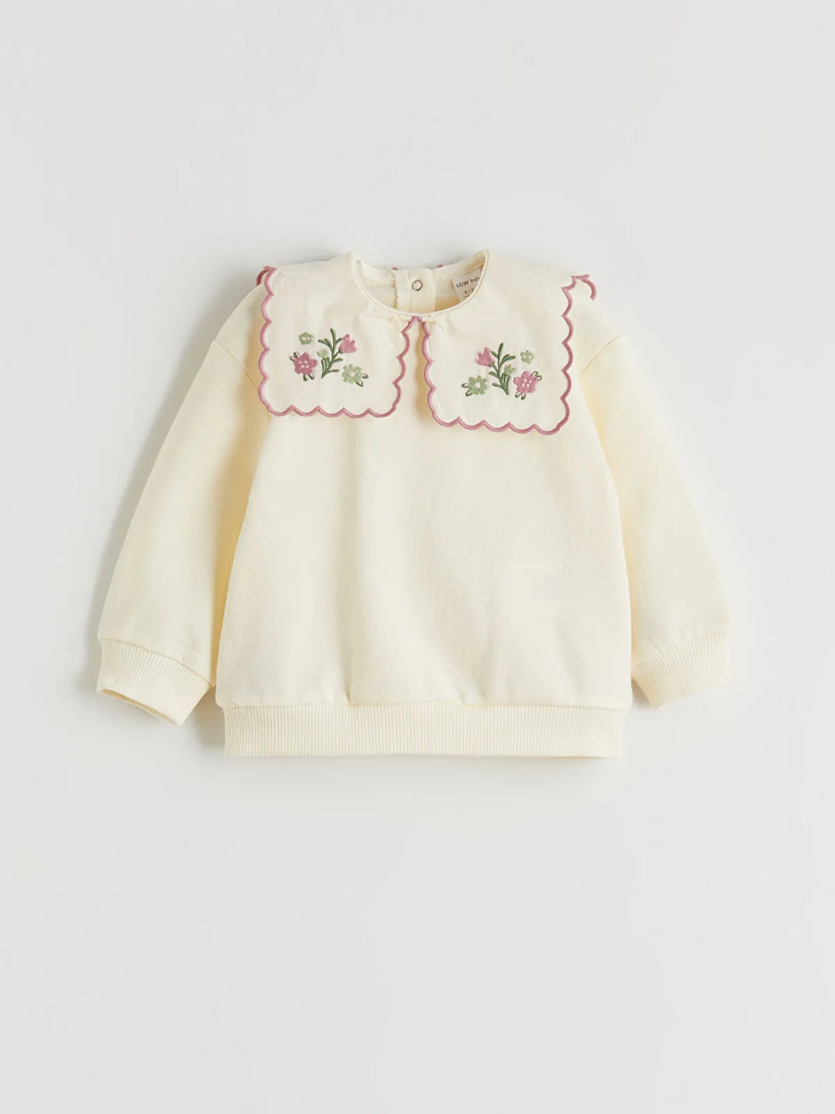 Off-white Peter Pan collar girl's blouse and trousers.